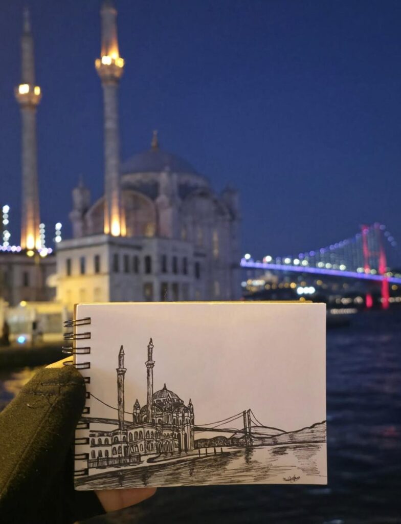 Sketchbook drawing of a mosque and bridge beside the illuminated waterfront